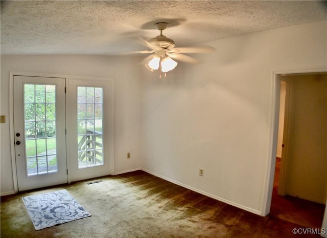 entryway featuring a textured ceiling, carpet floors, a ceiling fan, and baseboards