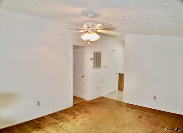 spare room featuring visible vents, baseboards, a ceiling fan, and carpet floors