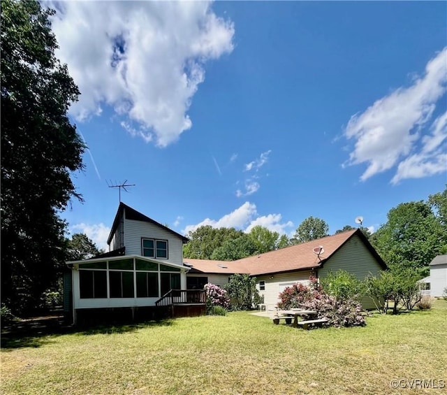 rear view of house with a yard, a sunroom, and an attached garage
