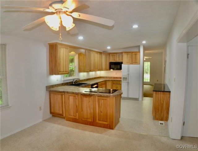 kitchen featuring black appliances, a peninsula, recessed lighting, and a sink