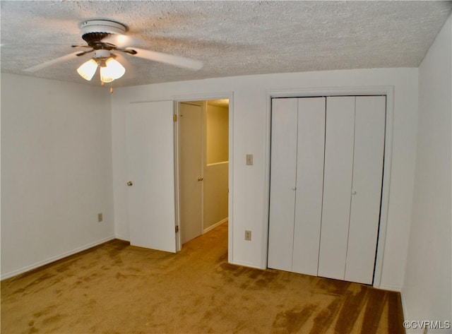 unfurnished bedroom featuring a closet, a textured ceiling, ceiling fan, and carpet floors