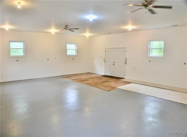garage featuring a ceiling fan and baseboards