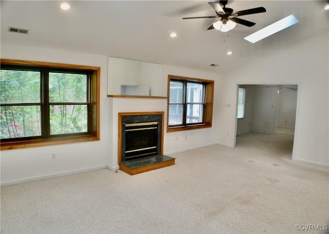 unfurnished living room with a ceiling fan, plenty of natural light, visible vents, and carpet floors