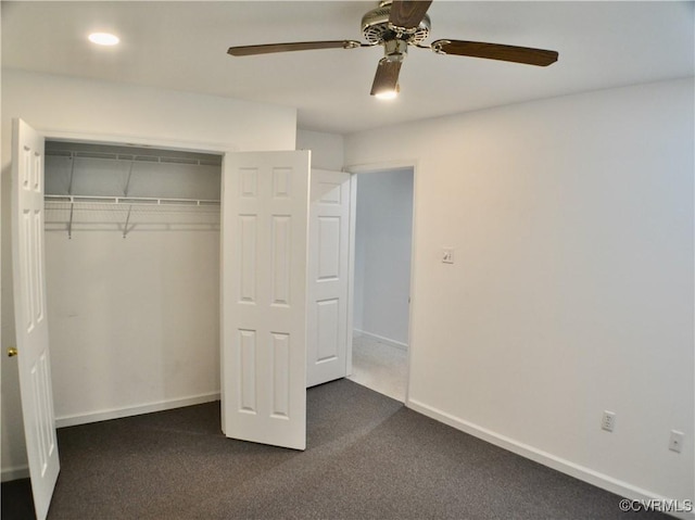 unfurnished bedroom featuring ceiling fan, dark colored carpet, a closet, and baseboards