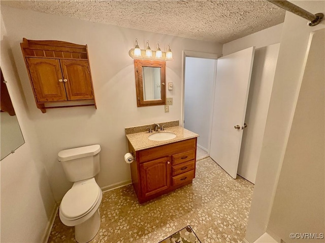 bathroom with a textured ceiling, toilet, and vanity