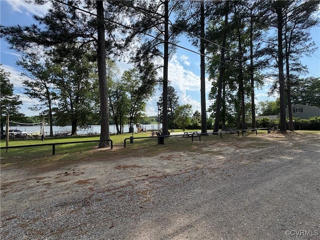 view of property's community with a water view and fence