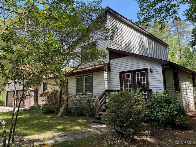 209 Pineview Dr, Hartfield, VA 23071 - view of side of property featuring an attached garage, a lawn, and driveway