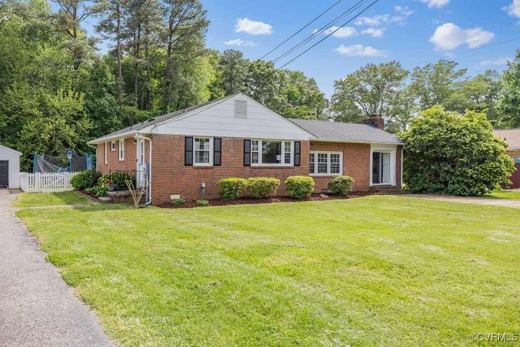 view of front of property with a chimney, brick siding, and crawl space