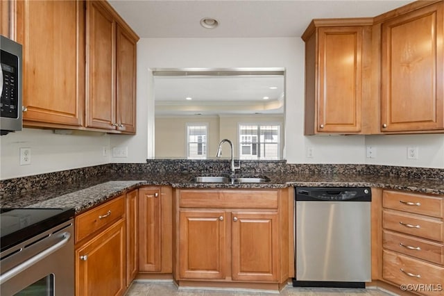 5529 Frog Pond Ln, Virginia Beach, VA 23455 - kitchen with dark stone counters, stainless steel appliances, brown cabinetry, and a sink