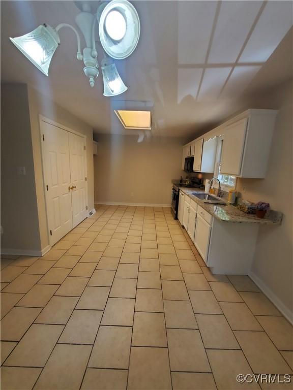 349 Whispering Pine Ln, Bumpass, VA 23024 - kitchen featuring electric range, a sink, baseboards, and white cabinets