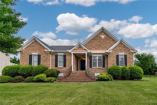 view of front of house featuring brick siding and a front yard