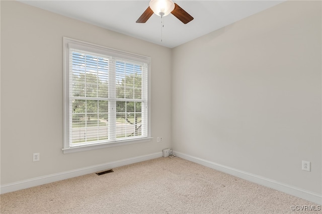 carpeted empty room with a ceiling fan and baseboards