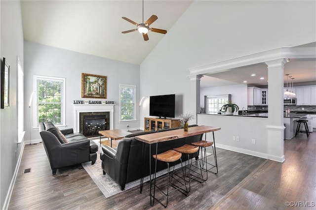 living room with ornate columns, high vaulted ceiling, ceiling fan, plenty of natural light, and recessed lighting