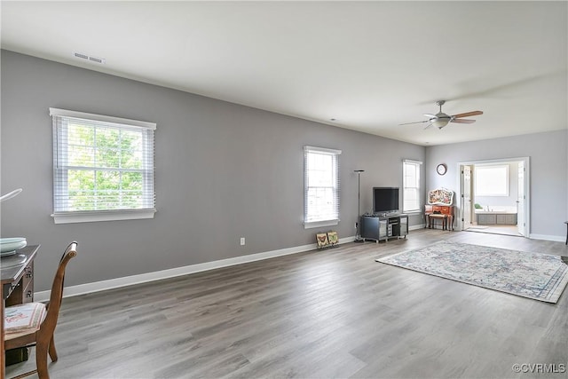 living room featuring ceiling fan, wood finished floors, and baseboards