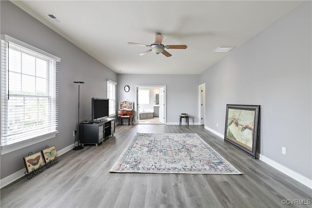 living room with a ceiling fan, wood finished floors, and baseboards