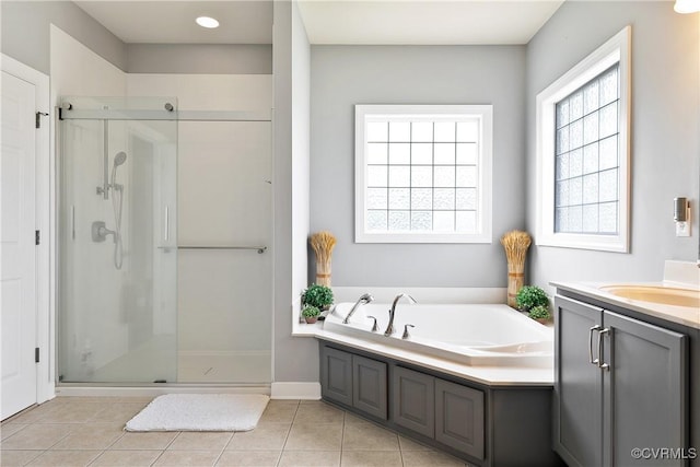 full bath featuring a stall shower, a bath, vanity, tile patterned floors, and baseboards