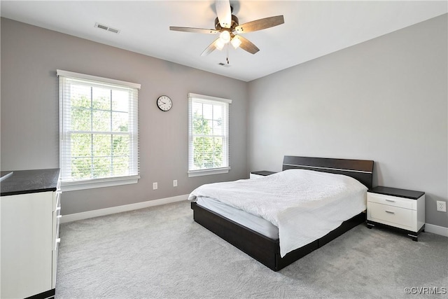 carpeted bedroom featuring multiple windows, baseboards, and ceiling fan