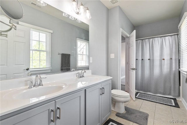 bathroom with tile patterned floors, toilet, double vanity, and shower / bath combo with shower curtain
