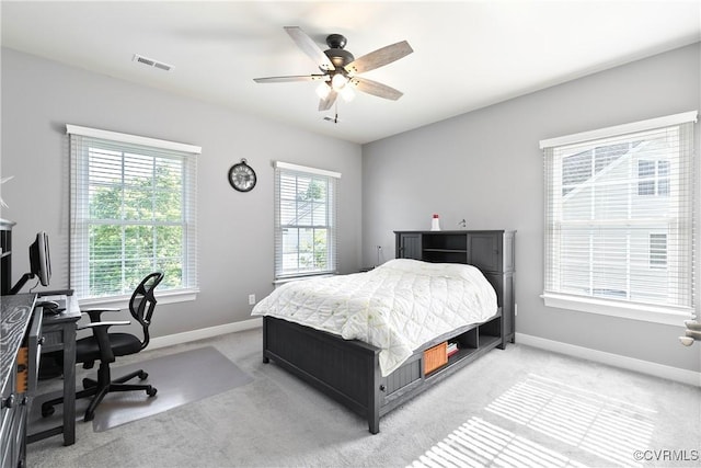 bedroom with light carpet, baseboards, and a desk