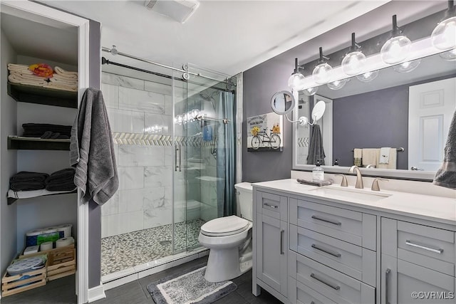 bathroom featuring a stall shower, toilet, and vanity