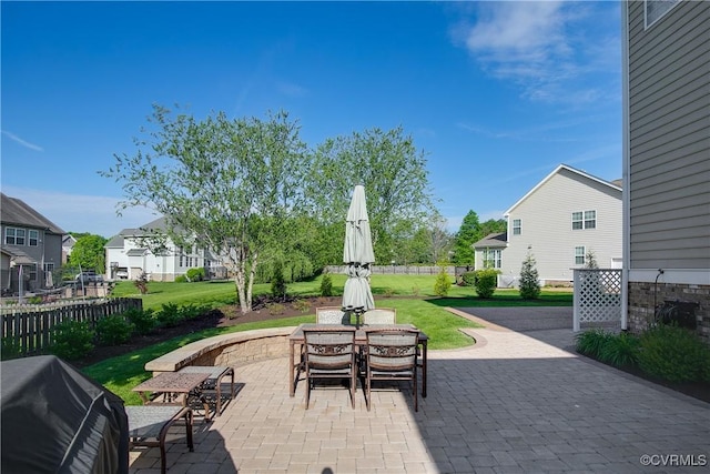 view of patio / terrace featuring a residential view, outdoor dining area, and grilling area