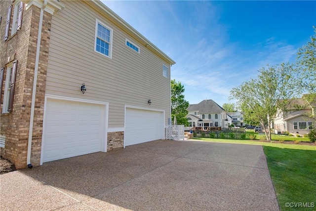 view of side of property with driveway, a garage, and a residential view