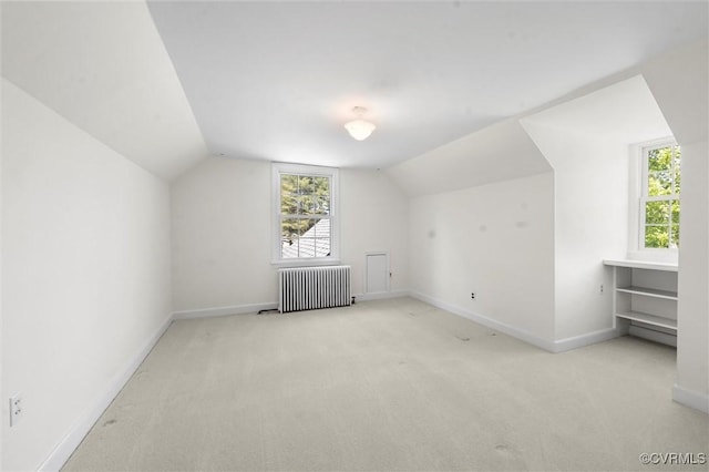 additional living space with radiator heating unit, carpet flooring, baseboards, and lofted ceiling