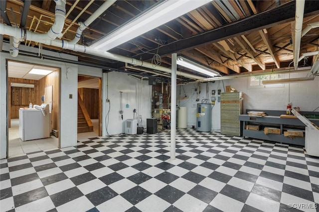 below grade area with tile patterned floors, electric water heater, independent washer and dryer, and stairway