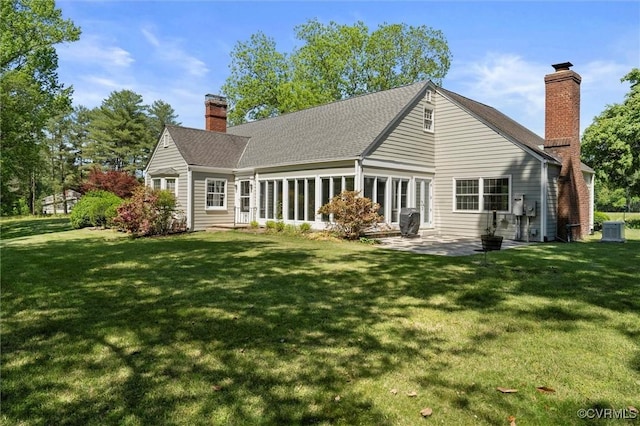 back of house with a chimney, central AC unit, a yard, a patio area, and a shingled roof