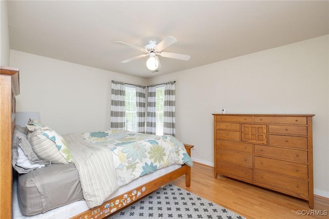 bedroom featuring light wood-style floors, baseboards, and ceiling fan