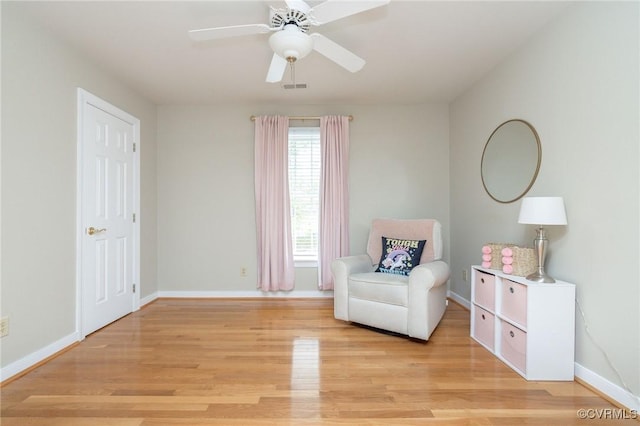 sitting room featuring visible vents, light wood-style flooring, baseboards, and ceiling fan