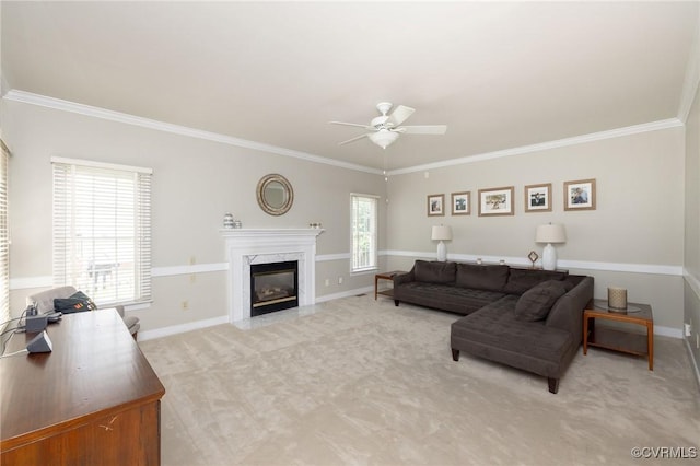 living room featuring a fireplace, ceiling fan, crown molding, and light colored carpet