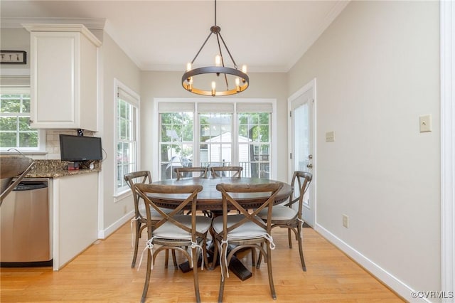 dining area with an inviting chandelier, crown molding, baseboards, and light wood-type flooring