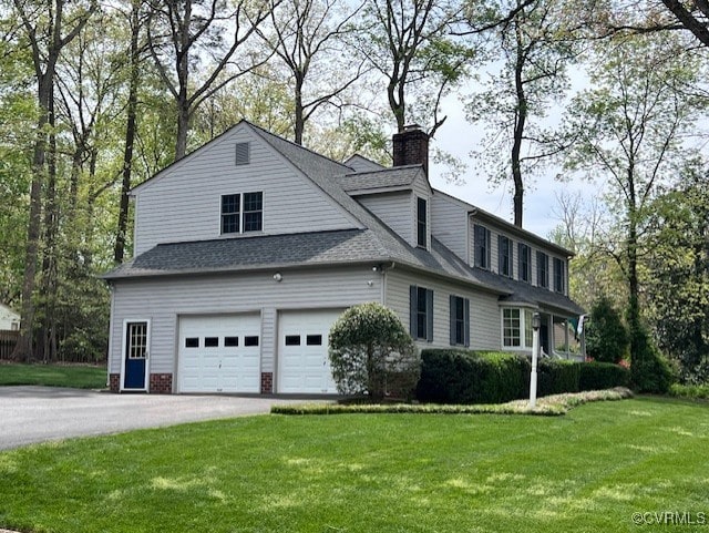 view of home's exterior with a chimney, a yard, roof with shingles, and asphalt driveway