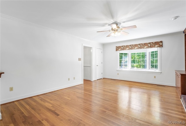 unfurnished living room with a ceiling fan, light wood-style flooring, ornamental molding, and baseboards