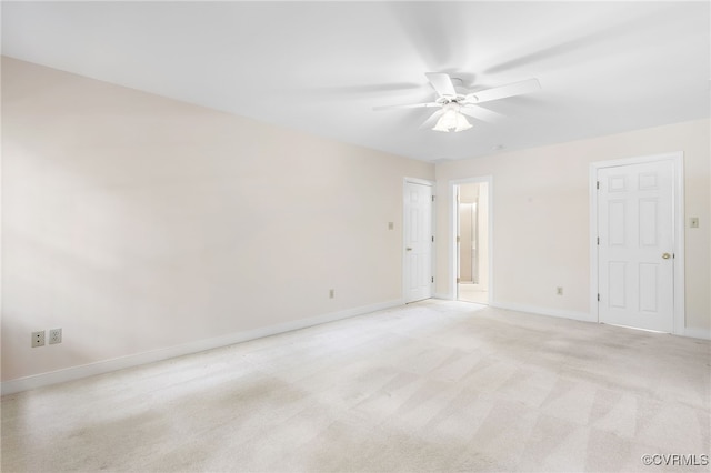 spare room featuring baseboards, a ceiling fan, and light colored carpet