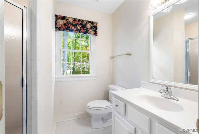 bathroom featuring a stall shower, toilet, baseboards, vanity, and tile patterned floors
