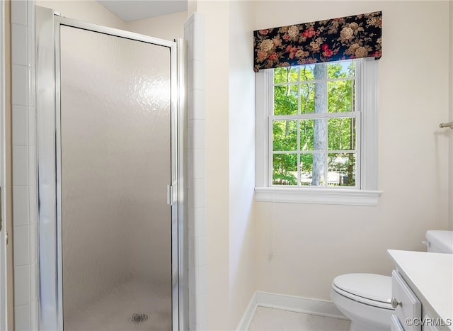 bathroom featuring vanity, a stall shower, baseboards, and toilet