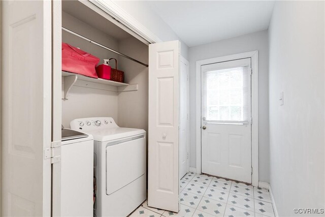 clothes washing area with baseboards, light floors, laundry area, and washing machine and dryer