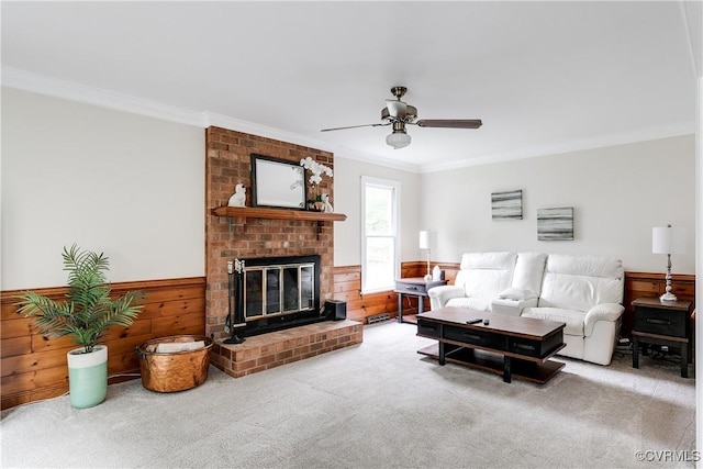 living area featuring wainscoting, a fireplace, ornamental molding, and carpet