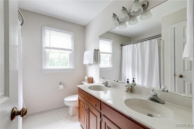 full bathroom featuring baseboards, tile patterned floors, toilet, and a sink