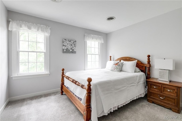 bedroom featuring light carpet, baseboards, and multiple windows