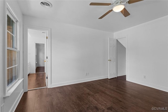 unfurnished bedroom with wood finished floors, baseboards, a ceiling fan, and multiple windows
