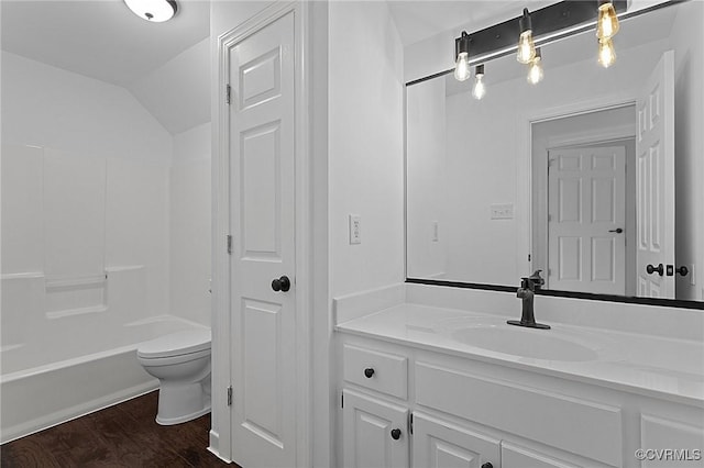 full bathroom with toilet, lofted ceiling, wood finished floors, vanity, and tub / shower combination