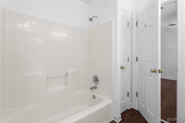 bathroom with shower / washtub combination and wood finished floors