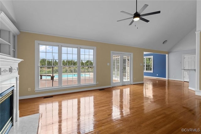 unfurnished living room featuring wood finished floors, visible vents, a ceiling fan, baseboards, and a glass covered fireplace
