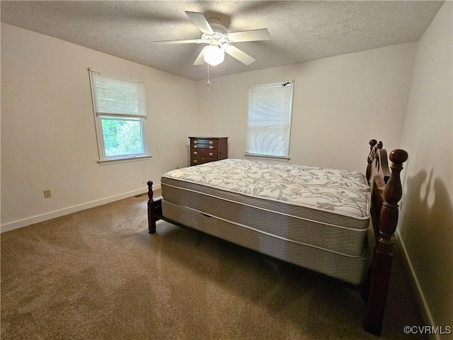 bedroom featuring carpet, a textured ceiling, baseboards, and ceiling fan