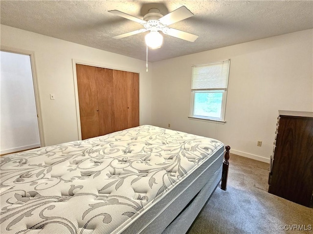 carpeted bedroom featuring baseboards, a closet, ceiling fan, and a textured ceiling