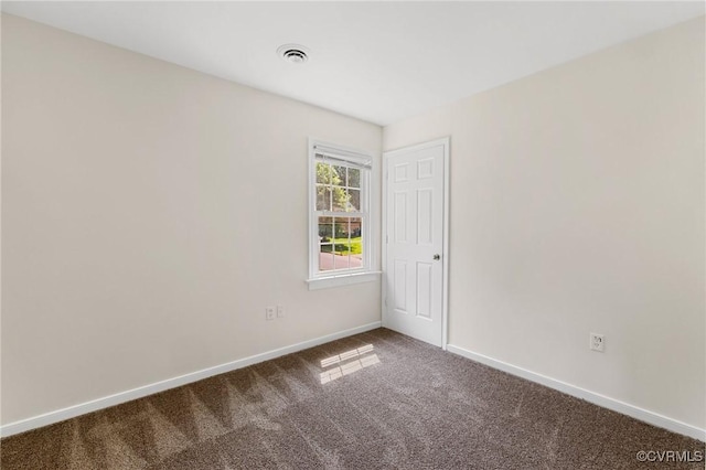 unfurnished room featuring carpet, visible vents, and baseboards
