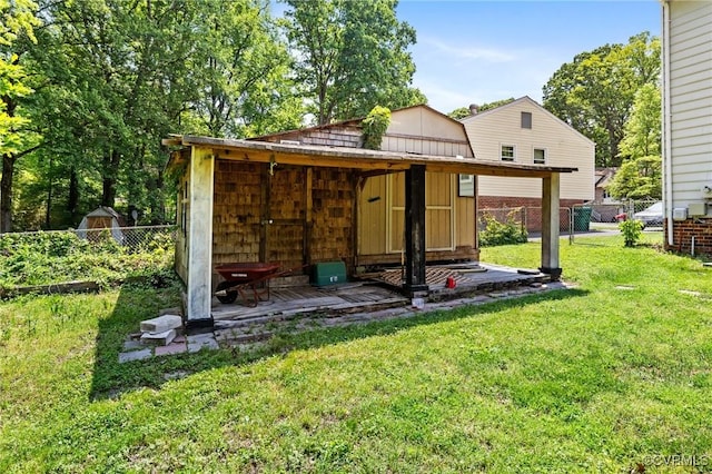 rear view of house featuring a fenced backyard, a storage shed, a yard, and an outdoor structure